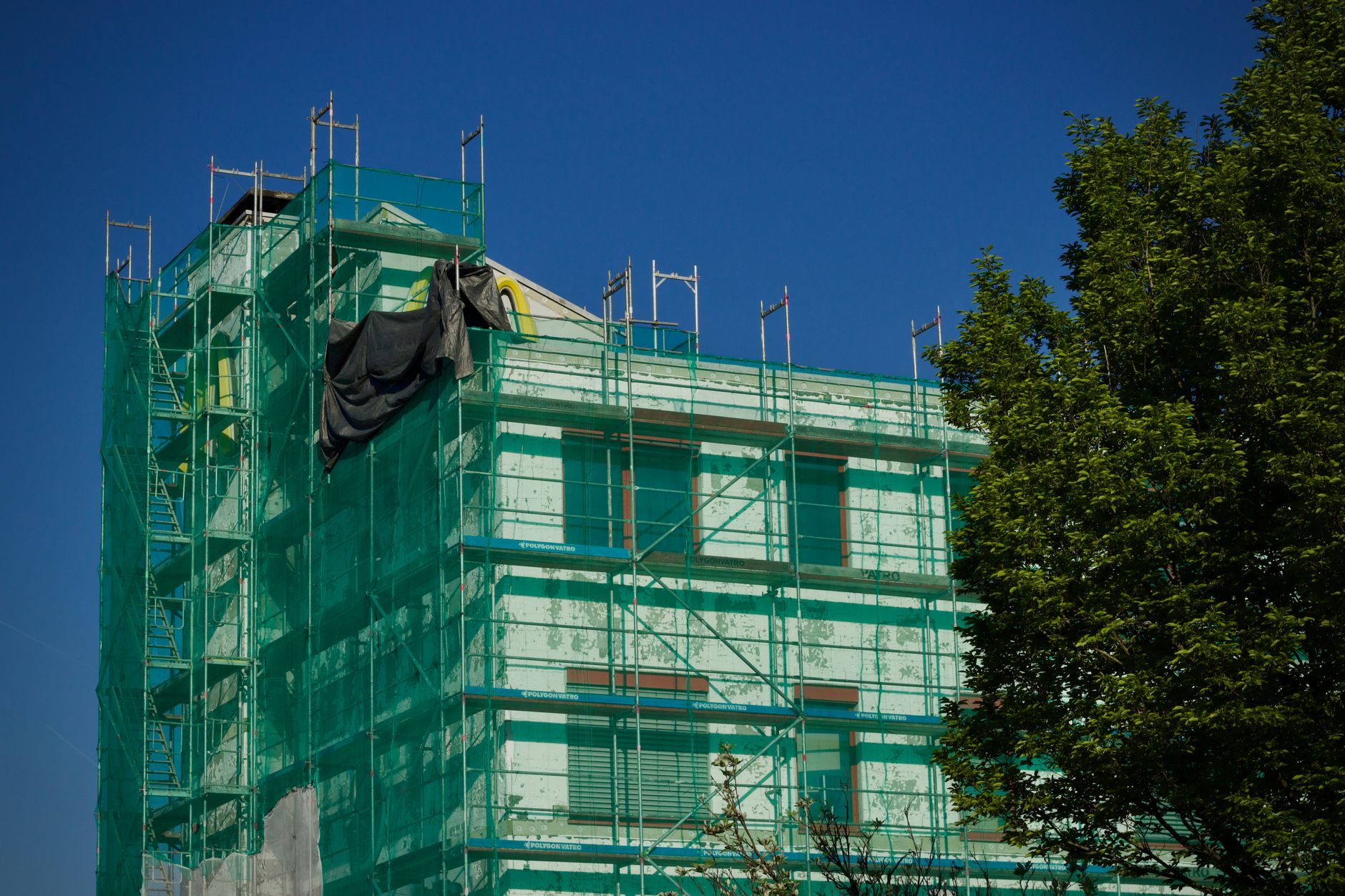 三階建て戸建ての足場費用がかかる施工中の外観