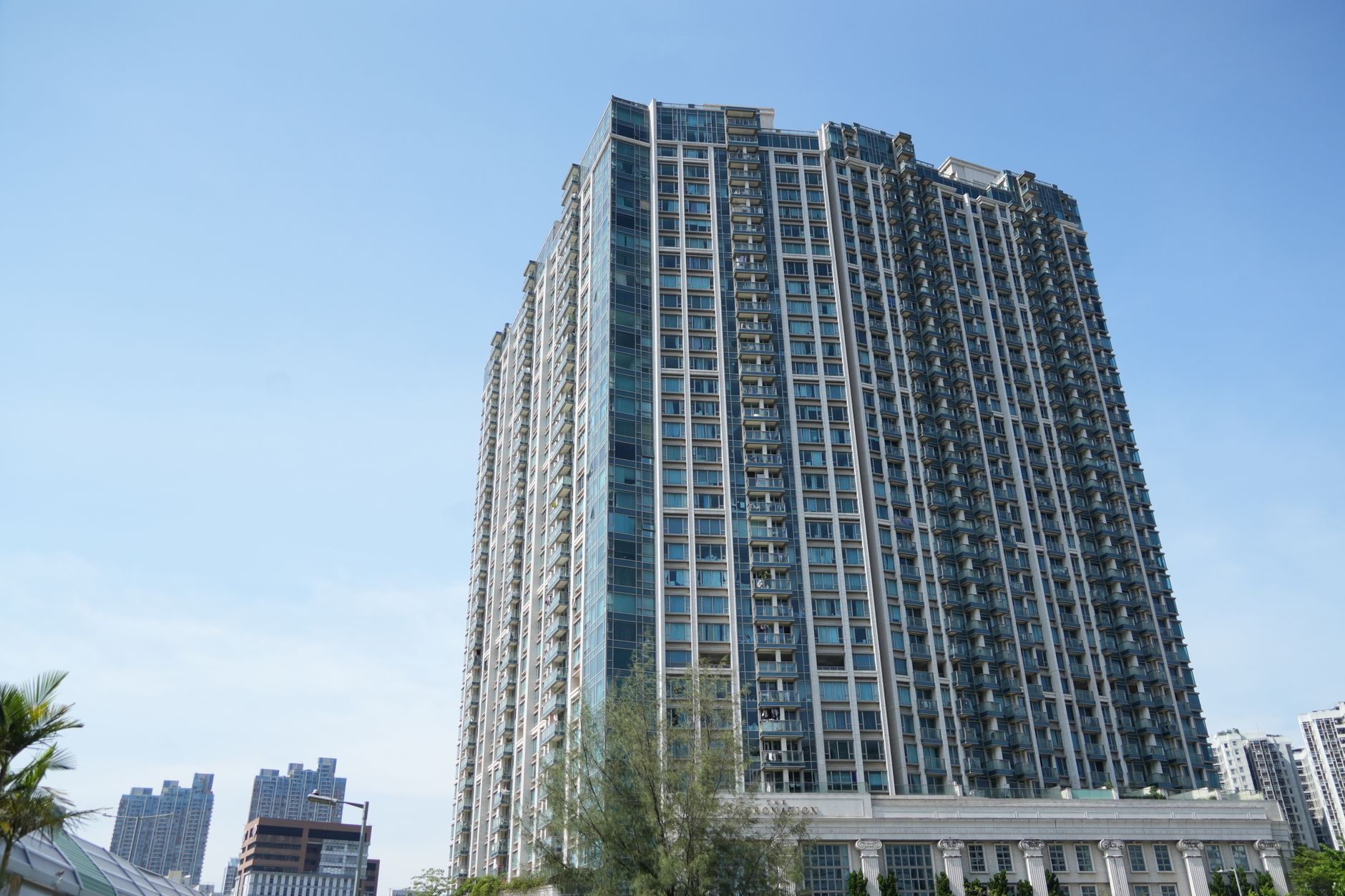 晴天の住宅街で戸建て住宅に組まれた足場とメッシュシートで足場設置費用を検討